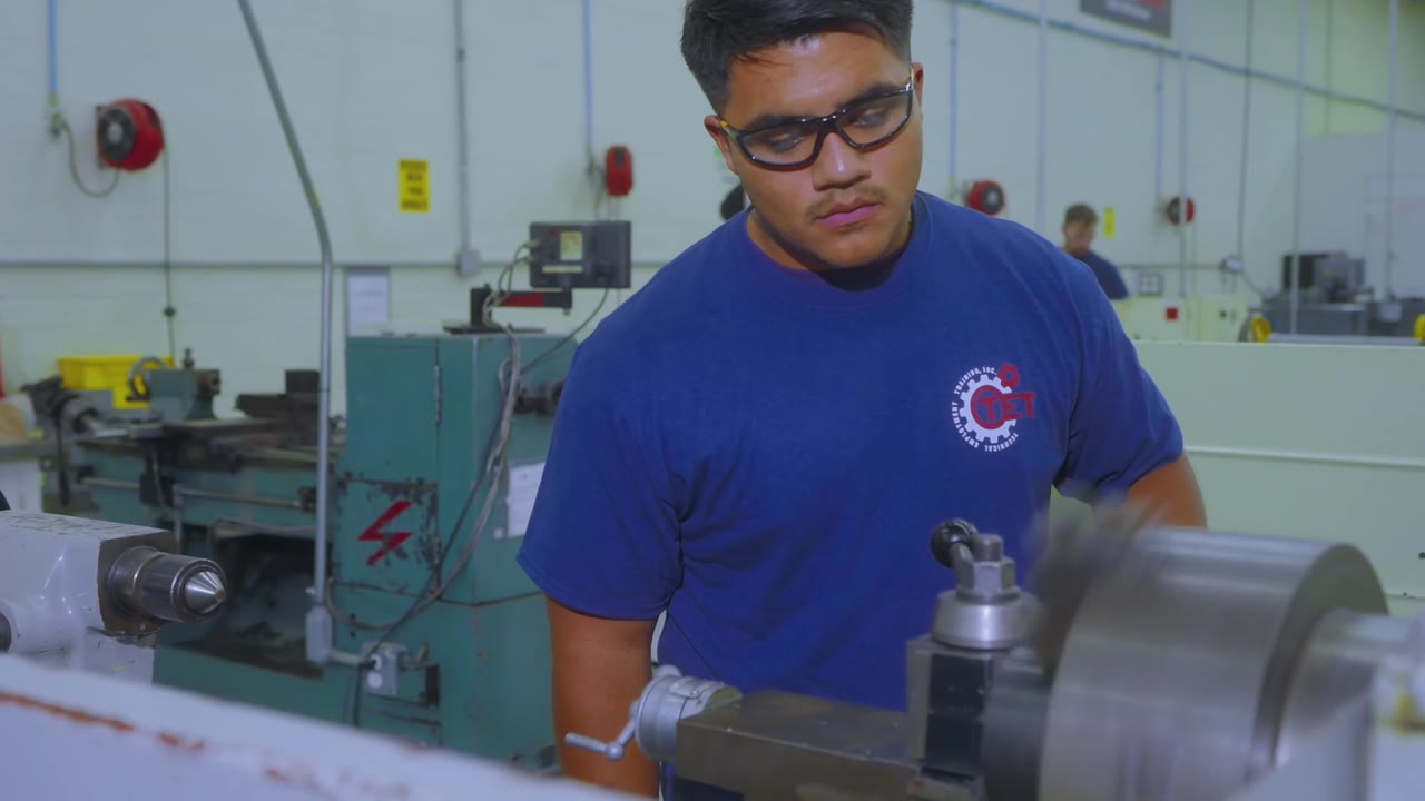 A student on a lathe at Technical Employment Training